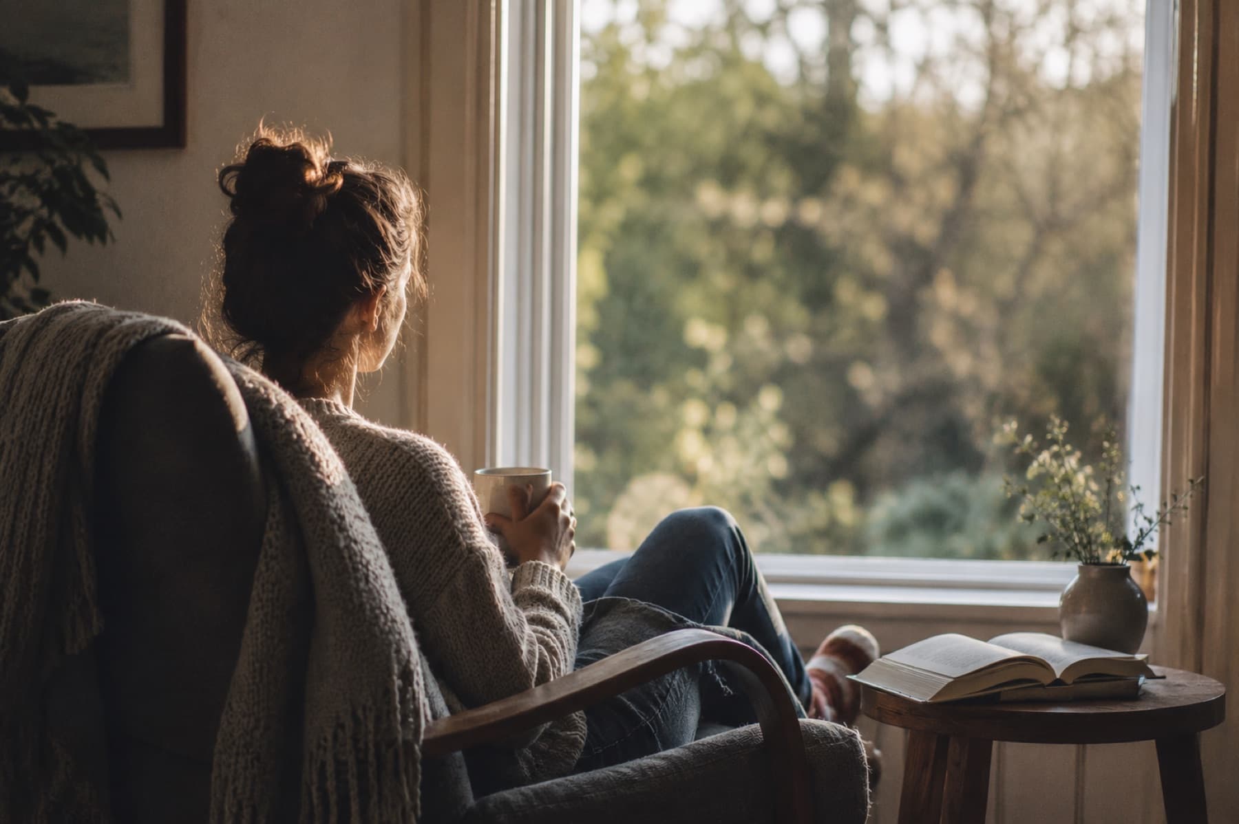 A woman reflecting quietly beside a window at home